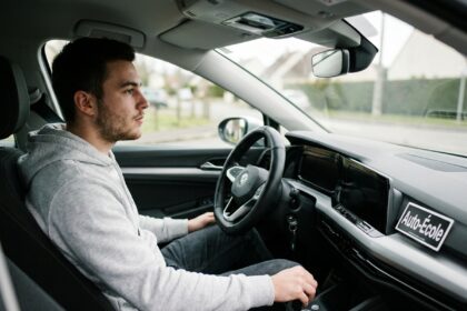 Jeune conducteur apprenant à rétrograder sur une boîte de vitesses manuelle dans une voiture d'auto-école