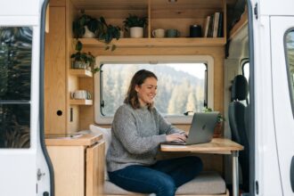Femme dans un van moderne travaillant sur son ordinateur