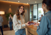 Jeune femme souriante à la réception d'hôtel