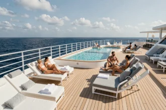 Pont extérieur d'un navire de croisière Virgin Voyages avec piscine et passagers adultes se relaxant en mer